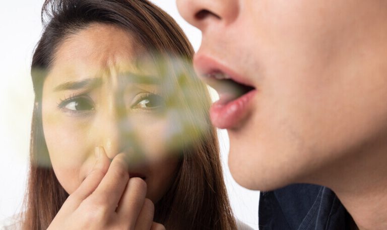 Ağız Kokusu Nedeniyle Rahatsızlık Yaşayan Bir Kişi Elini Ağzına Kapatıyor.